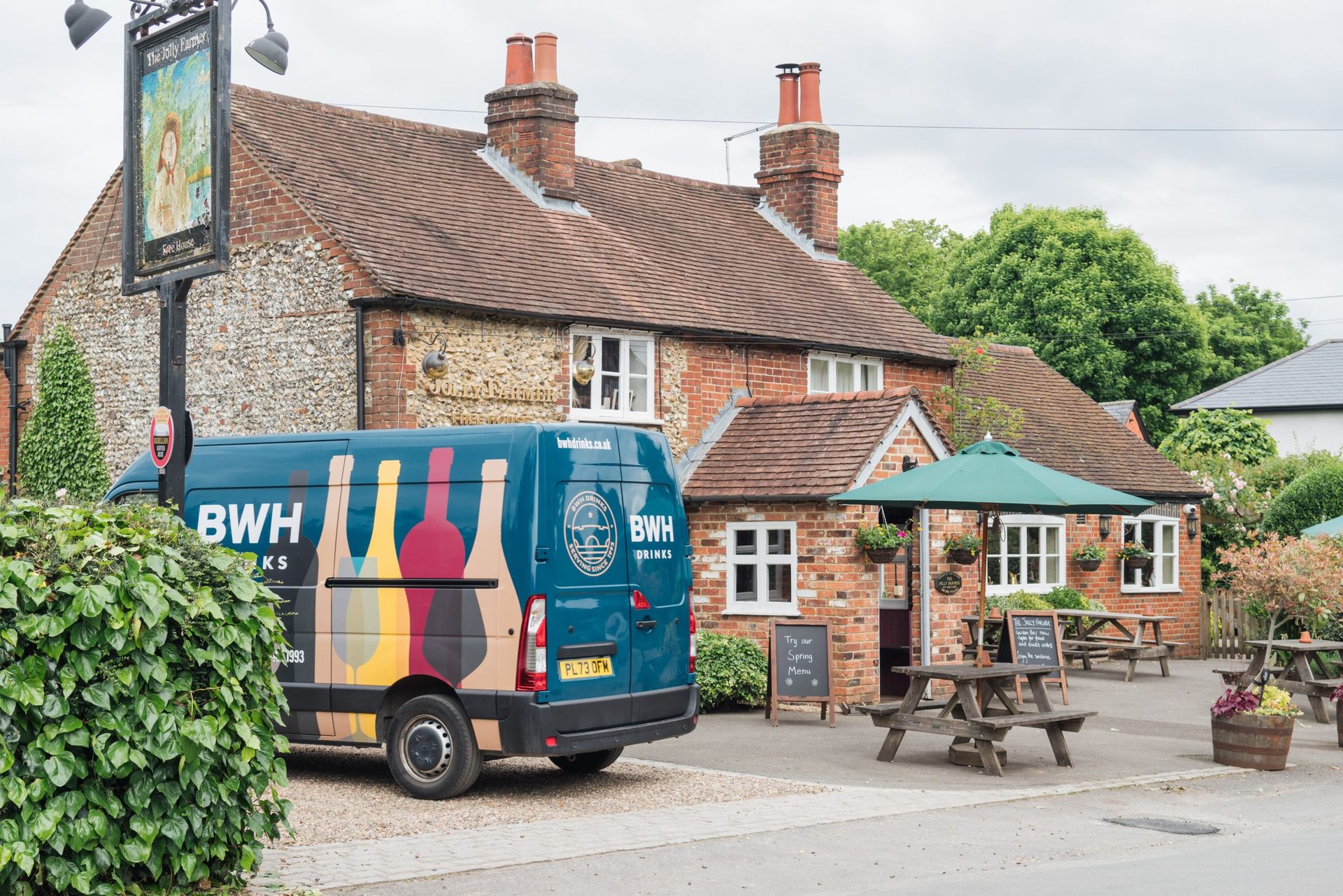 A BWH Drinks van outside the Jolly Farmer, a country pub, on a summer day